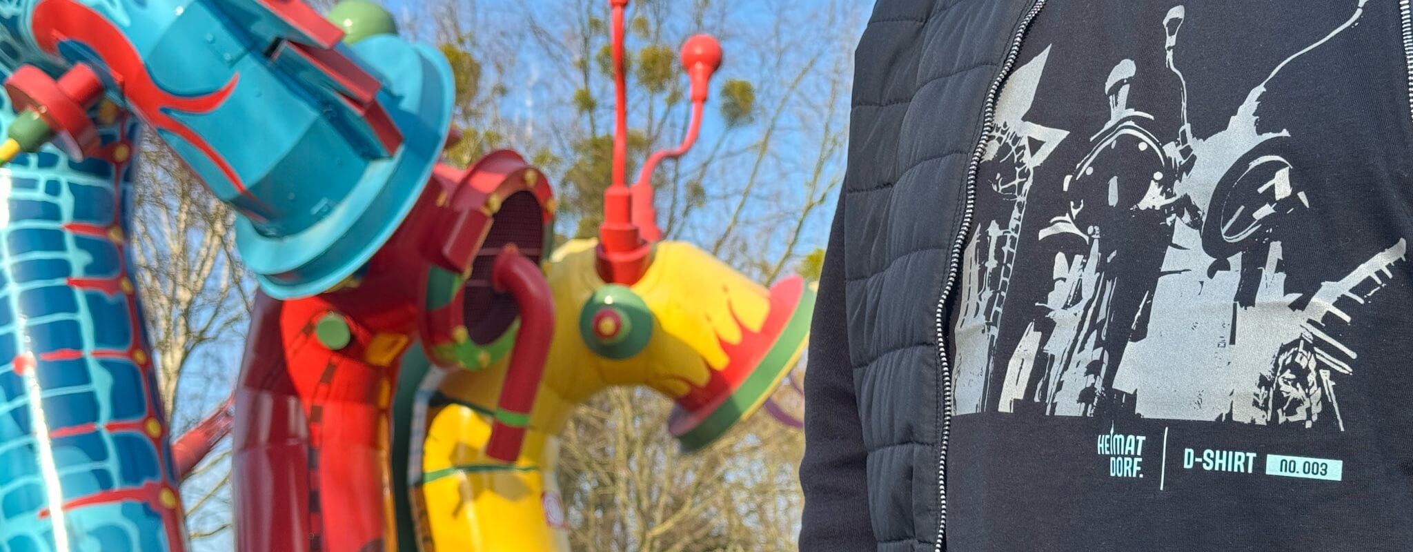 Ein Mann mit einem D-Shirt steht vor dem Motiv seines Düsseldorfer D-Shirts