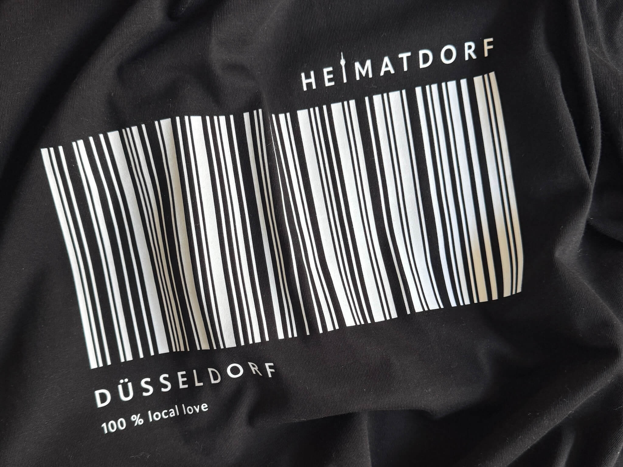 D-Shirt Ausschnitt mit dem Text Heimatdorf Düsseldorf 100 % local love