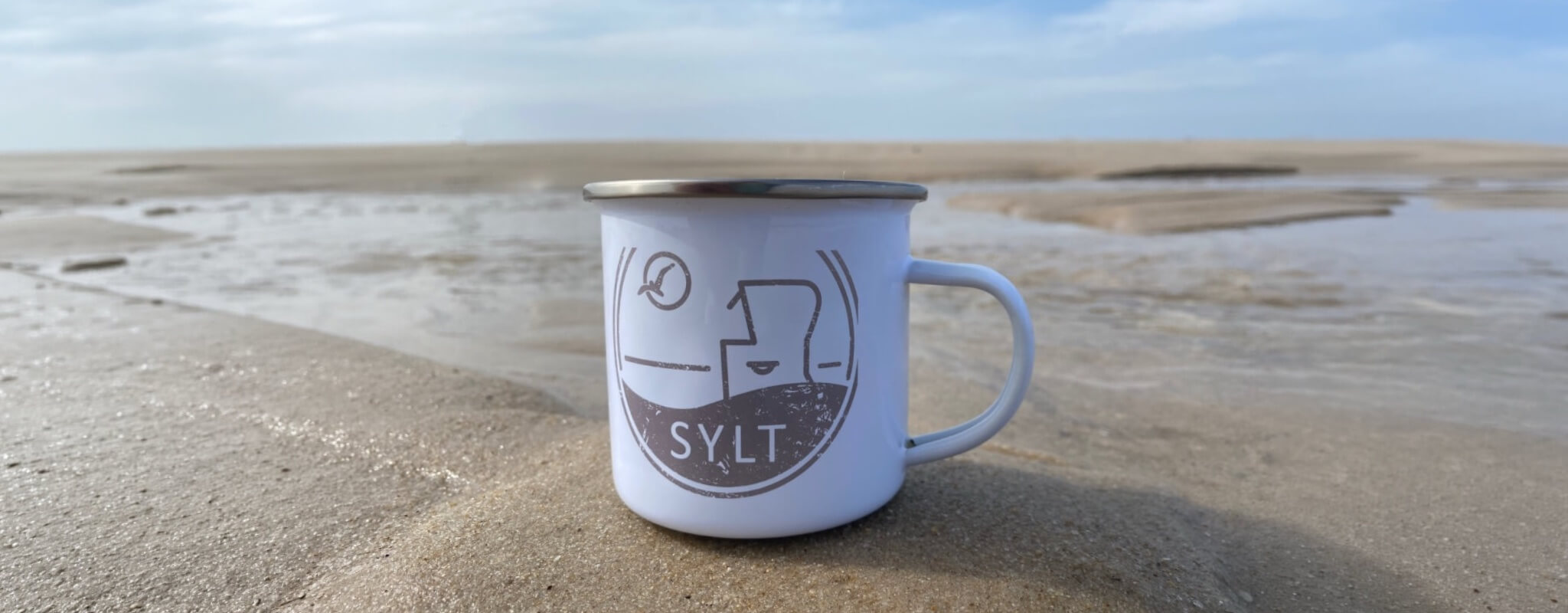 Eine BEACHLIFE SYLT Tasse auf einer Sylter Sandbank